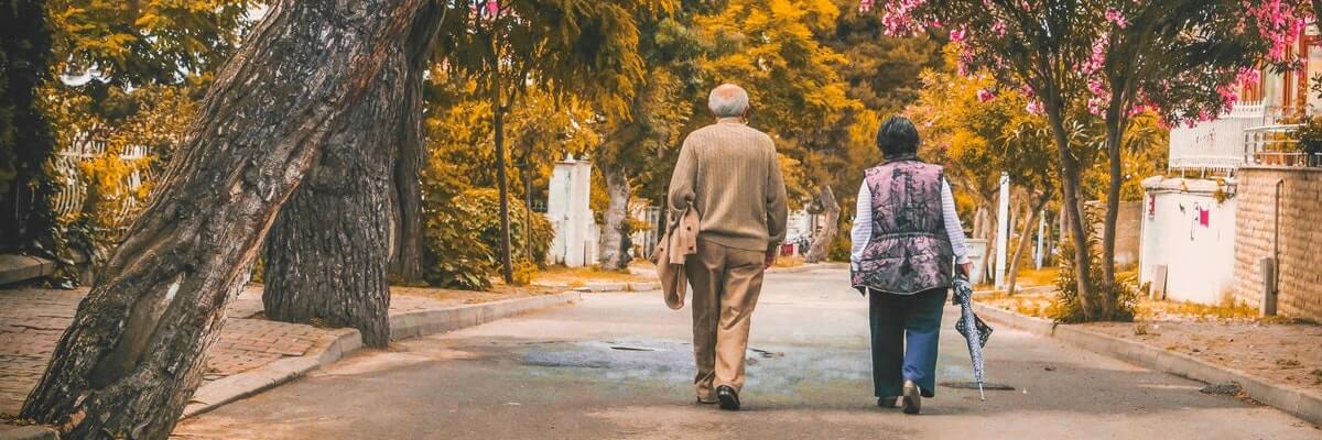 two elderly people walking