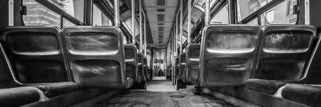 empty aisle of a mass transit vehicle (bus) in black and white