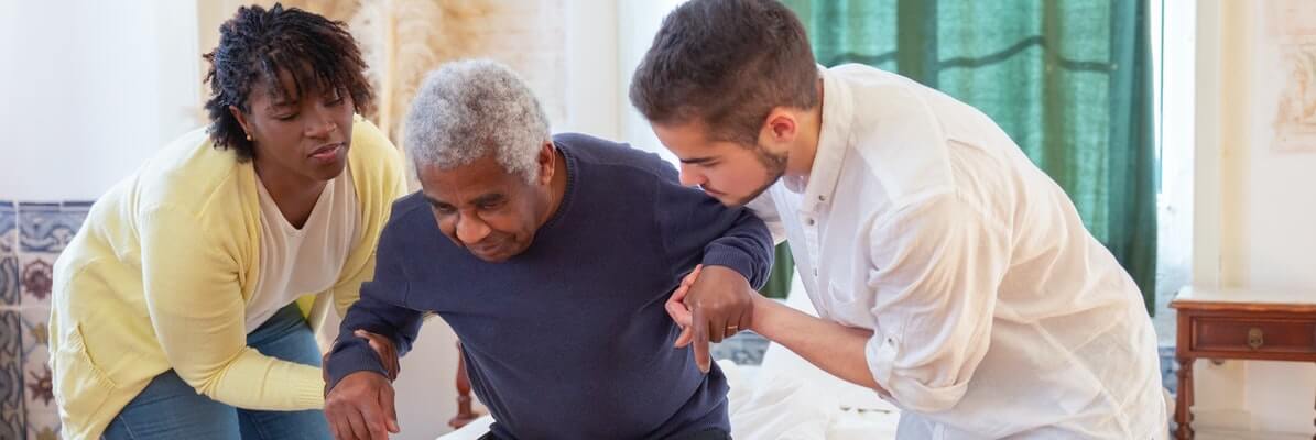 old man being held by two nursing home staff members